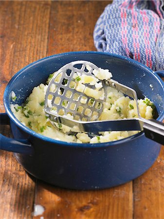 prepared dish - Mashed potatoes with herbs in a pot with a potato masher Foto de stock - Sin royalties Premium, Código: 659-06372889