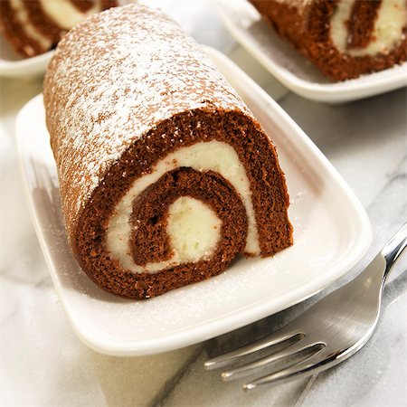 Individual Cream Filled Pumpkin Roll Dusted with Powdered Sugar Stock Photo - Premium Royalty-Free, Code: 659-06372922