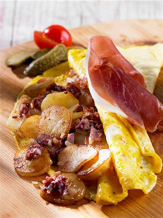 Une omelette de pays avec les pommes de terre, bacon et jambon Photographie de stock - Premium Libres de Droits, Code: 659-06373028