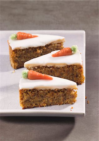 Three slices of carrot cake topped with icing and marzipan carrots Foto de stock - Sin royalties Premium, Código: 659-06373037