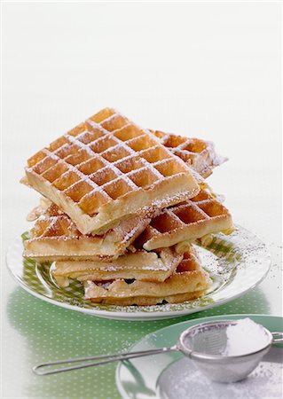 A stack of waffles dusted with icing sugar Stock Photo - Premium Royalty-Free, Code: 659-06373045