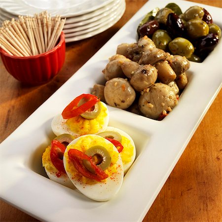 Three Part Serving Dish with Deviled eggs, Marinated Mushrooms and Olives; Bowl of Toothpicks Foto de stock - Sin royalties Premium, Código: 659-06373050