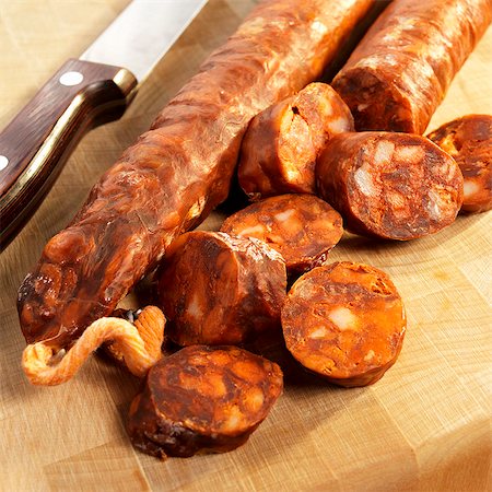 simsearch:659-06902104,k - Partially Sliced Spanish Chorizo on a Cutting Board Stock Photo - Premium Royalty-Free, Code: 659-06373051