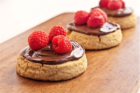 simsearch:659-06670961,k - Biscuits de sablé avec propagation de chocolat aux noisettes et framboises ; Sur une planche à découper Photographie de stock - Premium Libres de Droits, Code: 659-06373119