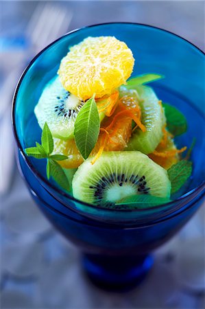 Fresh Kiwi, Orange and Mint Salad in a Blue Glass Foto de stock - Sin royalties Premium, Código: 659-06373159