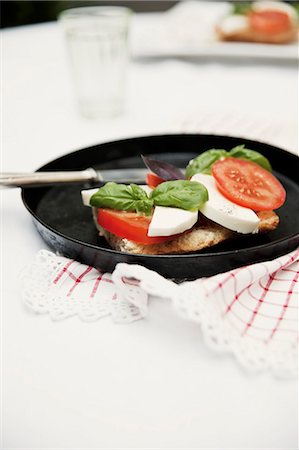 simsearch:659-06372847,k - Bread topped with tomatoes, mozzarella and basil Foto de stock - Sin royalties Premium, Código: 659-06373225