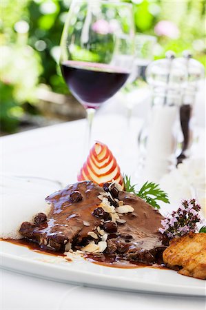 Rhenish Sauerbraten (marinated pot roast) with raisins and napkin dumplings and a glass of red wine Stock Photo - Premium Royalty-Free, Code: 659-06373289