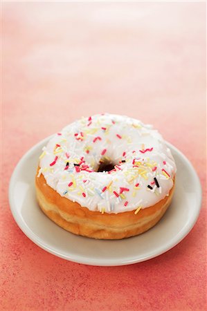 sweet food - An iced doughnut with sugar sprinkles Stock Photo - Premium Royalty-Free, Code: 659-06373518
