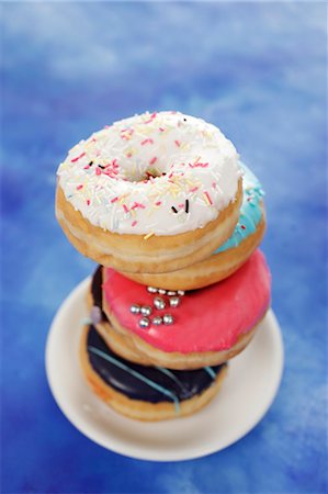 simsearch:659-06373902,k - Four doughnuts with colourful glaze and sugar sprinkles Foto de stock - Sin royalties Premium, Código: 659-06373523