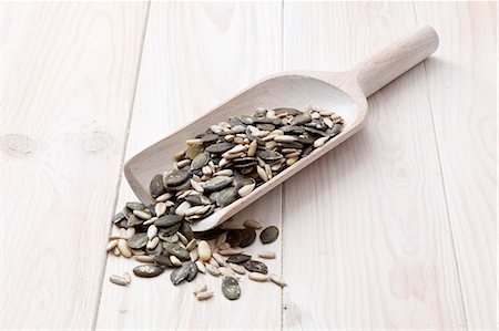 simsearch:659-07609881,k - Sunflower seeds, pumpkin seeds and pine nuts on a wooden scoop Stock Photo - Premium Royalty-Free, Code: 659-06373591