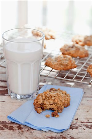 flaked oat - Homemade Oatmeal Cookies with a Glass of Milk; One Cookie with Bite Taken Out; Cookies on Cooling Rack Stock Photo - Premium Royalty-Free, Code: 659-06373669