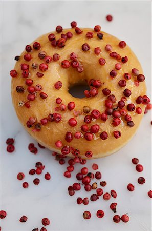 A doughnut decorated with pink peppercorns Stock Photo - Premium Royalty-Free, Code: 659-06373686