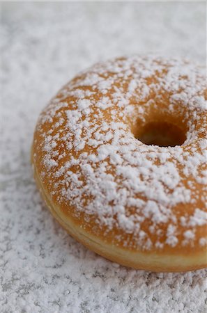 sugary - A doughnut dusted with icing sugar Stock Photo - Premium Royalty-Free, Code: 659-06373688