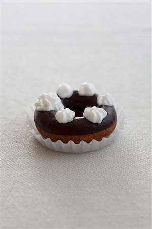 doughnut - Un beignet avec glaçage au chocolat et de blobs de crème Photographie de stock - Premium Libres de Droits, Code: 659-06373728