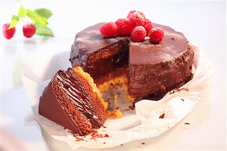 simsearch:659-02213086,k - Un gâteau au chocolat garni de framboises, en tranches Photographie de stock - Premium Libres de Droits, Code: 659-06373771