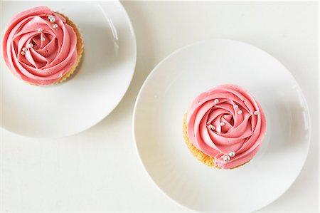 soft fruit creme - Two cupcakes decorated with strawberry cream and silver balls Stock Photo - Premium Royalty-Free, Code: 659-06373872