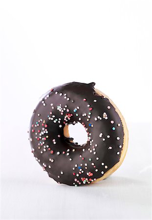 simsearch:659-06373902,k - A doughnut with chocolate glaze and colourful sugar sprinkles Fotografie stock - Premium Royalty-Free, Codice: 659-06494095