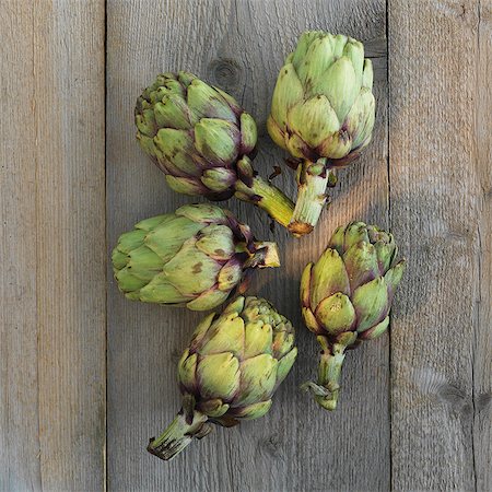 simsearch:659-06494798,k - Five artichokes on a wooden surface Photographie de stock - Premium Libres de Droits, Code: 659-06494144