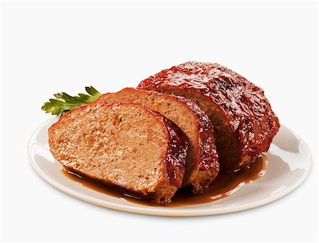 fleisch - Partially Sliced Meatloaf on a Plate; White Background Stockbilder - Premium RF Lizenzfrei, Bildnummer: 659-06494471