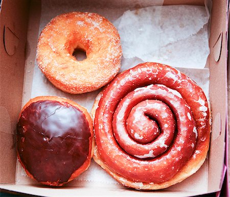 Three Assorted Doughnuts in a Cardboard Take Out Box Stock Photo - Premium Royalty-Free, Code: 659-06494515