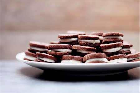 sucré - Cream-filled chocolate cookies on a plate Photographie de stock - Premium Libres de Droits, Code: 659-06494775