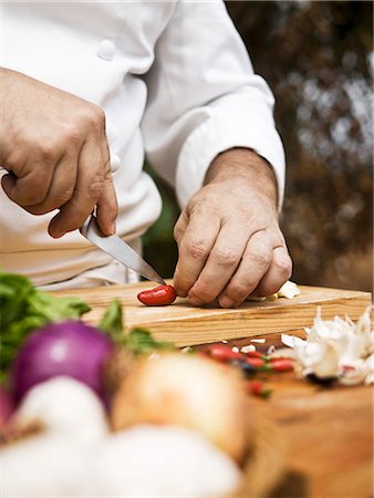 A chef slicing a chilli pepper Fotografie stock - Premium Royalty-Free, Codice: 659-06494837