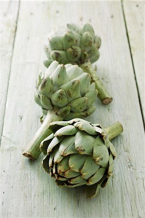 simsearch:659-06494889,k - Three artichokes on a wooden surface Photographie de stock - Premium Libres de Droits, Code: 659-06494886