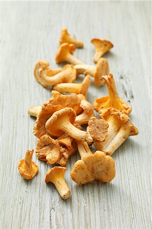 Fresh chanterelle mushrooms on a wooden surface Stock Photo - Premium Royalty-Free, Code: 659-06494903