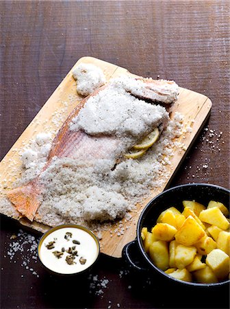 Fish in a salt crust with a side of potatoes Stock Photo - Premium Royalty-Free, Code: 659-06494917
