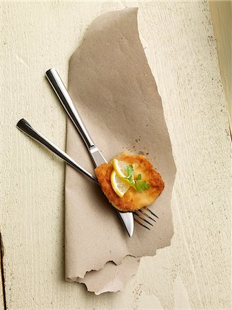 An escalope with lemon on a set of cutlery Stock Photo - Premium Royalty-Free, Code: 659-06495058