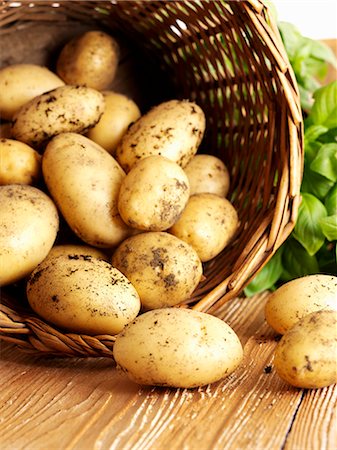 New potatoes falling out of a basket Stock Photo - Premium Royalty-Free, Code: 659-06495256