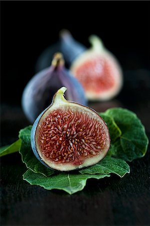 food and black background - Fresh figs, whole and halved, and fig leaves Stock Photo - Premium Royalty-Free, Code: 659-06495279