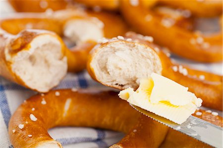 Pretzels being spread with butter Stock Photo - Premium Royalty-Free, Code: 659-06495374