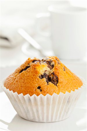A chocolate chip muffin on a white surface Foto de stock - Sin royalties Premium, Código: 659-06495370