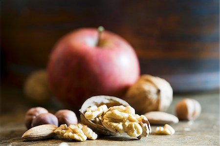 An arrangement of walnuts, nuts and an apple Stock Photo - Premium Royalty-Free, Code: 659-06495498