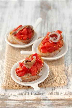 simsearch:659-07599054,k - Bread topped with tomatoes and anchovies (tapas, Spain) Photographie de stock - Premium Libres de Droits, Code: 659-06495512