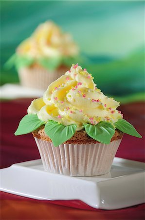 schokostreusel - A cupcake with yellow frosting and marzipan leaves Stockbilder - Premium RF Lizenzfrei, Bildnummer: 659-06495718