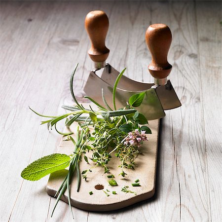 A bunch of herbs and a mezzaluna Stock Photo - Premium Royalty-Free, Code: 659-06493717