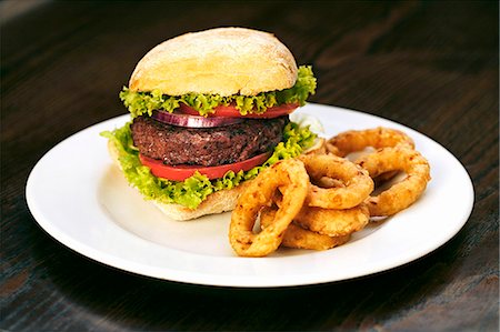 A beefburger with fried onion rings Stock Photo - Premium Royalty-Free, Code: 659-06493858