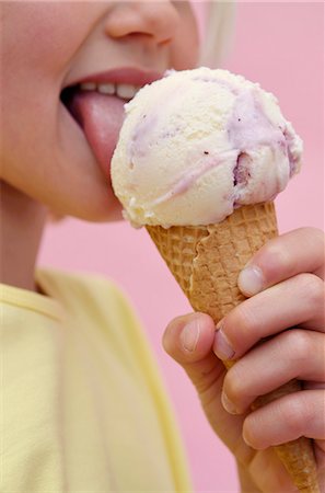 person eating ice cream - A girl eating an ice cream cone (sour cream ice cream with berries) Stock Photo - Premium Royalty-Free, Code: 659-06670856