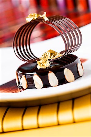 simsearch:659-06671429,k - Chocolate Cake with Sliced Almonds, Gold Foil, and a Chocolate Garnish Stock Photo - Premium Royalty-Free, Code: 659-06670859