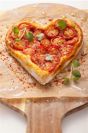 pizza - A heart-shaped pizza topped with tomatoes Photographie de stock - Premium Libres de Droits, Code: 659-06670892