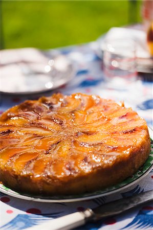 Whole Peach Upside Down Cake on a Sunny Outdoor Table Stock Photo - Premium Royalty-Free, Code: 659-06671012