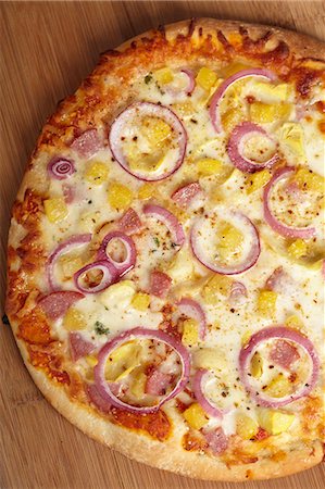 simsearch:862-07910994,k - Whole Hawaiian Pizza with Pineapple, Canadian Bacon and Red Onions; From Above Photographie de stock - Premium Libres de Droits, Code: 659-06671046