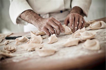 A chef rolling fresh tortellini in flour Stock Photo - Premium Royalty-Free, Code: 659-06671143