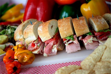 Party Sub Sliced with Toothpicks; On a Cutting Board; Peppers and Chips Stock Photo - Premium Royalty-Free, Code: 659-06671192