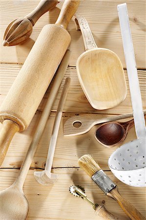 Kitchen utensils on a pale wooden surface Stock Photo - Premium Royalty-Free, Code: 659-06671273