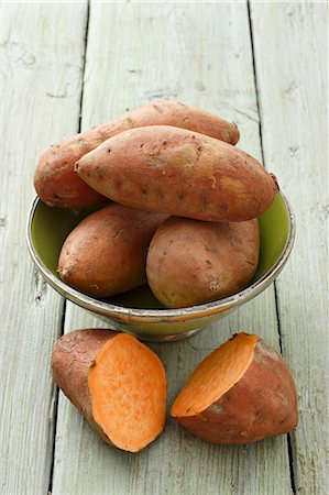 süßkartoffel - Whole sweet potatoes in a dish, with a halved sweet potato to the front Stockbilder - Premium RF Lizenzfrei, Bildnummer: 659-06671307