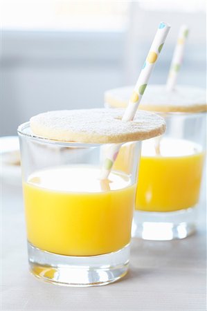 fête enfantine - Glasses of orange juice with biscuit lids and drinking straws Photographie de stock - Premium Libres de Droits, Code: 659-06671311