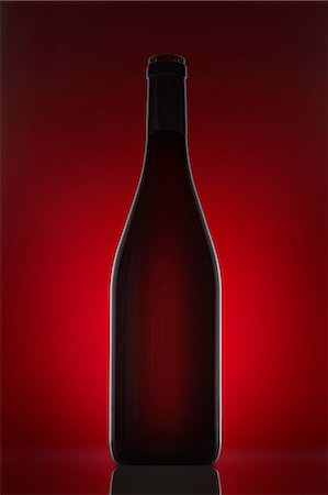 A red wine bottle against a red background Stock Photo - Premium Royalty-Free, Code: 659-06671362